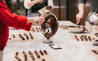 Chocolate being poured onto paper to make truffles
