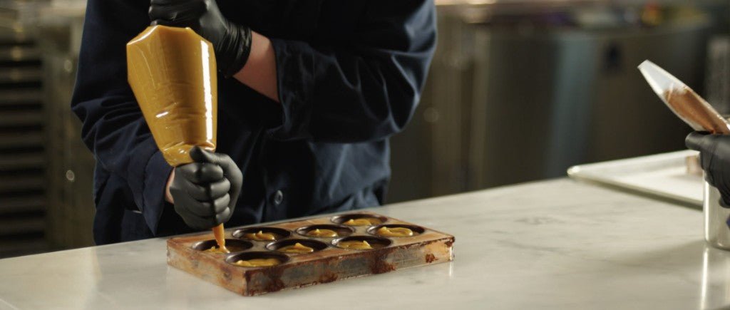 Advent calendar chocolatier piping caramel (desktop banner)